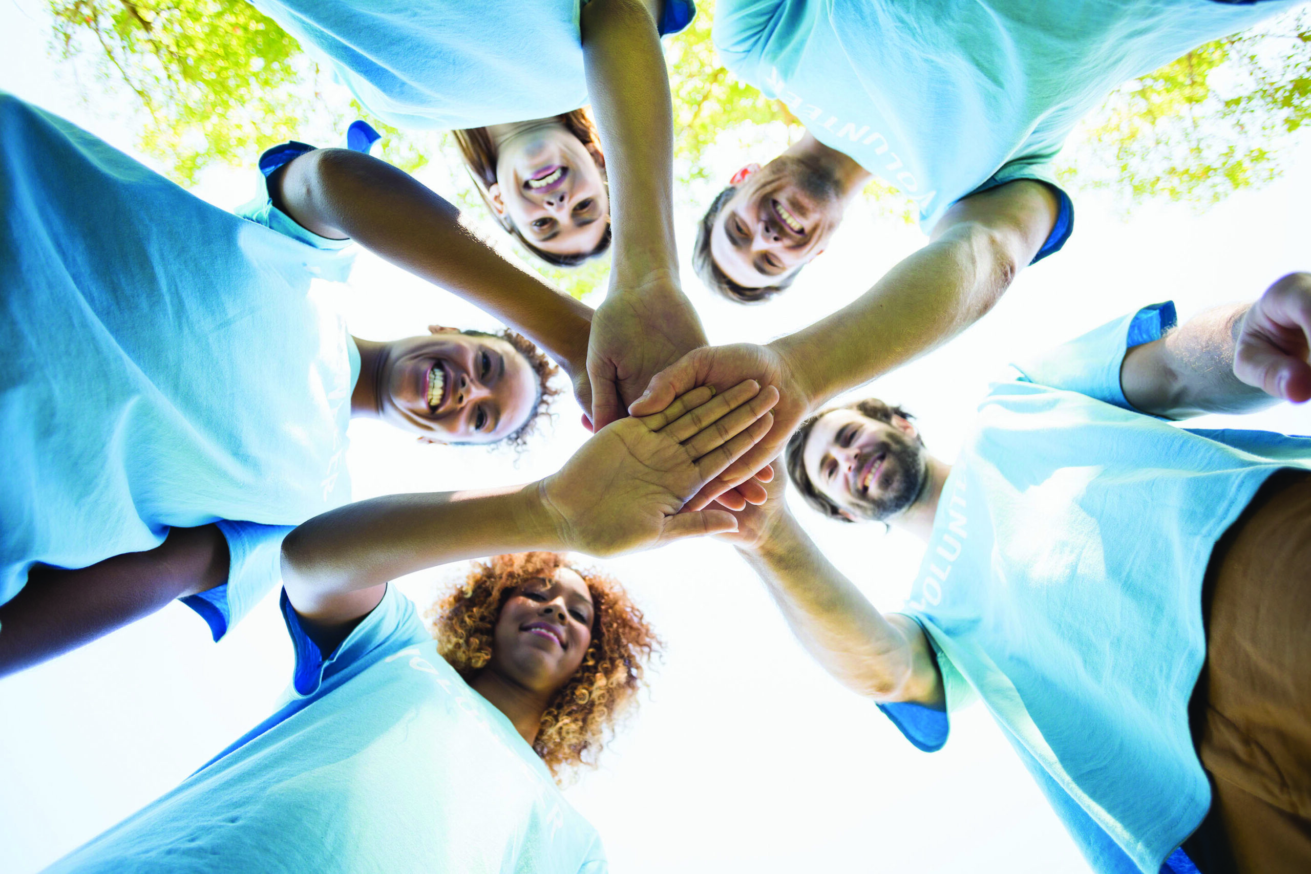 Group of volunteer forming huddles in park